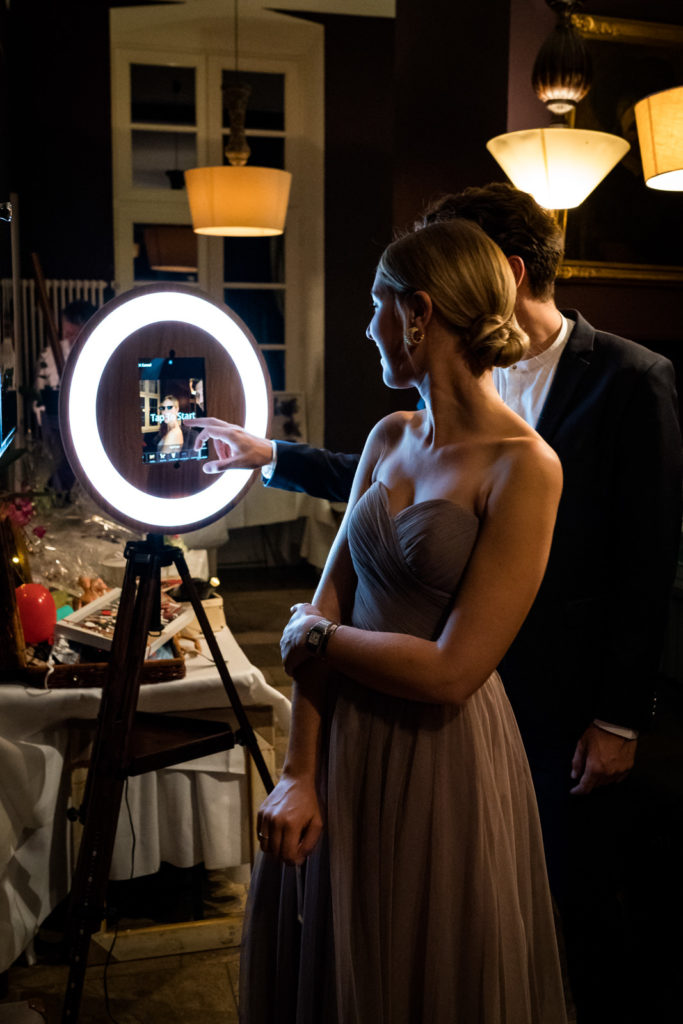 Päarchen steht vor einer Fotobox und macht ein Foto